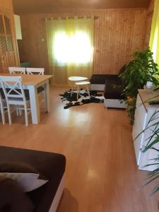 uma sala de estar com mesa e cadeiras em Domek u Prezesa 