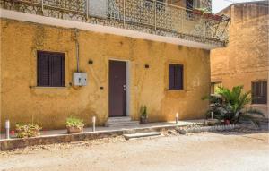 un bâtiment jaune avec une porte sur son côté dans l'établissement Nice Apartment In Gizzeria With Kitchen, à Gizzeria