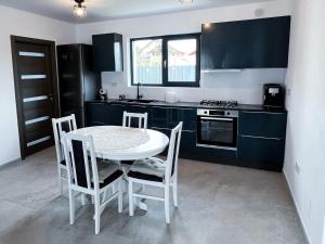 a kitchen with a table and chairs in a kitchen at Casa Maya in Curtea de Argeş