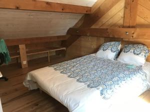 a bed in a room with wooden walls and wooden floors at Grande demeure familiale in Les Déserts