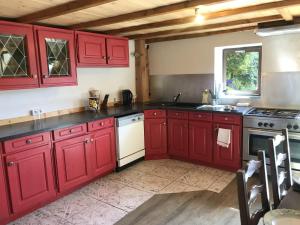萊代塞爾的住宿－Grande demeure familiale，厨房配有红色橱柜和白色炉灶。