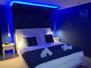 ein blaues Zimmer mit einem großen Bett mit blauen Lichtern in der Unterkunft La Suite Saphir – spa privatif in Nancy