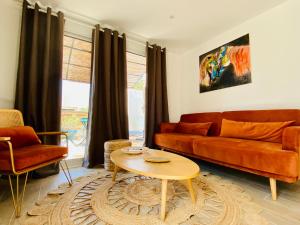 uma sala de estar com um sofá e uma mesa em Bella Vista Hôtel, Suites & Maisons em Porticcio