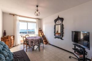 un salon avec une table et une télévision dans l'établissement Bel Orizonte, Grand appart 70m2 vue mer, à Ajaccio