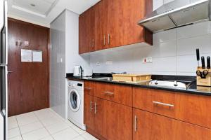 - une cuisine avec des placards en bois et un lave-linge dans l'établissement StoneTree - Studio with Amazing View in JLT, à Dubaï