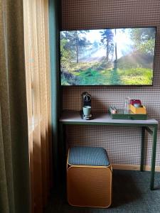 um quarto com uma mesa e uma televisão na parede em Spar Hotel Gårda em Gotemburgo