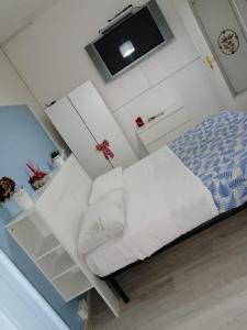 - une petite chambre avec un lit et une télévision dans l'établissement I Giardini di Capodimonte 2, à Naples