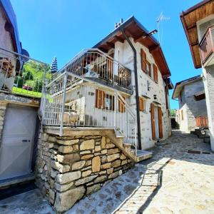 a stone house with a balcony on the side of it at Baita Margherita in Casargo