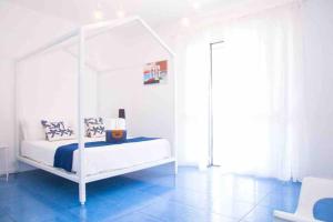 トラッペートにある4 bedrooms apartement at Piano di Trappeto 10 m away from the beach with sea view furnished terrace and wifiの青いフロアの客室の白いベッド1台