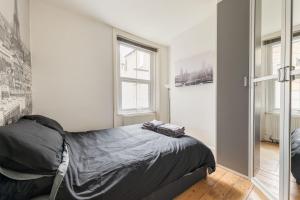 Schlafzimmer mit einem Bett und einem Fenster in der Unterkunft Charming 1 Bed Flat w Courtyard in Central London in London