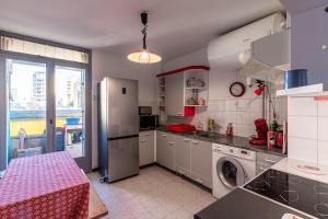 Il comprend une cuisine équipée d'un réfrigérateur et d'un lave-linge/sèche-linge. dans l'établissement Bel Orizonte, Grand appart 70m2 vue mer, à Ajaccio