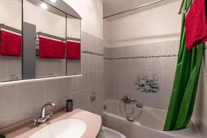 une salle de bain avec un lavabo, une baignoire et un miroir dans l'établissement Bel Orizonte, Grand appart 70m2 vue mer, à Ajaccio 11 autres photos