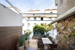 un balcón con mesa y sillas y un edificio en Lidador House Vila do Conde en Vila do Conde