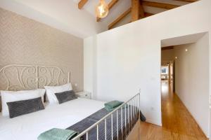 una camera con un letto bianco e una scala di Lidador House Vila do Conde a Vila do Conde
