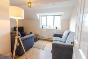 een woonkamer met twee blauwe banken en een lamp bij May Disc - Long Stay - Contractors in Swindon