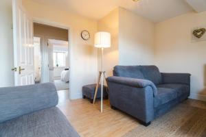 een woonkamer met een blauwe bank en een stoel bij May Disc - Long Stay - Contractors in Swindon
