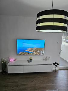 a living room with a tv on a white wall at Apartman Aleksandra u strogom centru grada in Bačka Topola