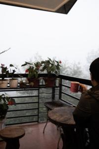 une personne assise à une table avec une tasse de café dans l'établissement The Greens Home & Garden - ENTIRE 3RD FLOOR, à Baguio