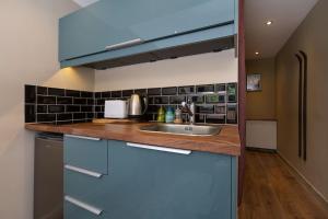 eine Küche mit blauen Schränken und einer Spüle in der Unterkunft Modern apartment with the best Mont Blanc view! in Chamonix-Mont-Blanc