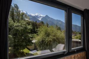 ein Fenster mit Blick auf einen schneebedeckten Berg in der Unterkunft Modern apartment with the best Mont Blanc view! in Chamonix-Mont-Blanc