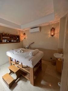 La salle de bains est pourvue d'un lit, d'un lavabo et de lumières. dans l'établissement Fashion Boutique Hotel, à Marrakech