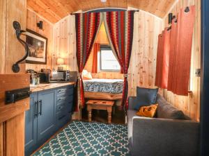 a small kitchen with a bed in a tiny house at Dunfell Shepherd's Hut in Dufton