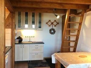 eine Küche mit weißen Schränken und einer Leiter in der Unterkunft Studio La Plagne Montalbert , 1 pièce, 4 personnes - FR-1-181-2478 in Aime La Plagne