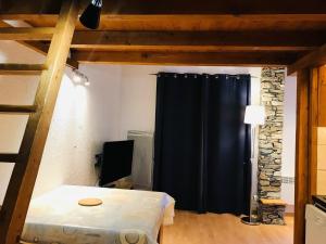 Zimmer mit einem Bett und einem schwarzen Vorhang in der Unterkunft Studio La Plagne Montalbert , 1 pièce, 4 personnes - FR-1-181-2478 in Aime La Plagne