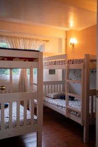 two bunk beds in a room with a window at The Greens Home & Garden - ENTIRE 3RD FLOOR in Baguio
