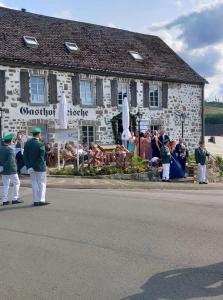 um grupo de pessoas em pé em frente a um edifício em Gasthof Feische em Hellefeld