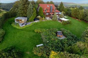 eine Luftansicht eines Hauses auf einem grünen Rasen in der Unterkunft EifelChalet Arduina mit Wintergarten und Saunahaus im Naturpark Hohes Venn- Eifel in Hellenthal