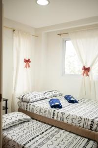 two twin beds in a room with a window at The Greens Home & Garden - ENTIRE 3RD FLOOR in Baguio