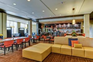 a restaurant with tables and chairs and a bar at Courtyard by Marriott Bridgeport Clarksburg in Bridgeport