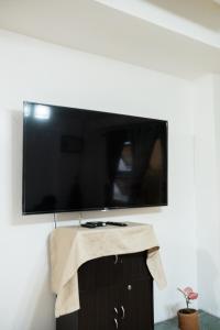 a flat screen tv hanging on a wall at The Greens Home & Garden - ENTIRE 3RD FLOOR in Baguio