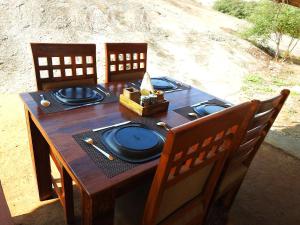 una mesa de madera con placas azules en la parte superior en Thour Nature Resort - Jawai Leopard Safari Camp, en Bera