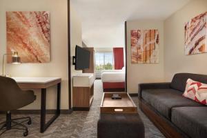 a hotel room with a couch and a bed at SpringHill Suites Phoenix Chandler/Fashion Center in Chandler