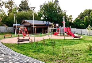 a park with a playground with a slide and swings at Departamento frente al lago Villarrica in Villarrica