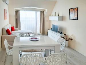 - un salon avec une table et des chaises blanches dans l'établissement Beachfront Panoramic Flat @ South Bay residence, à Varna