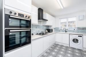 a white kitchen with a washer and dryer at Driveway Parking Garden Large House Good Location 