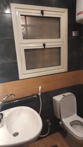 een badkamer met een wastafel, een toilet en een raam bij Madinaty 4 in Madinaty
