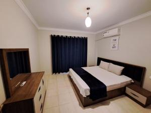 een slaapkamer met een bed en een zwart gordijn bij Madinaty 4 in Madinaty