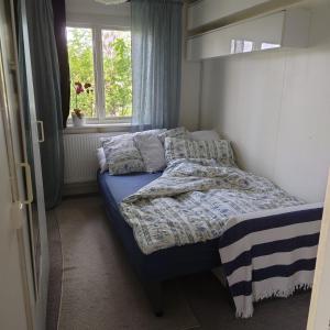 a bedroom with a bed with pillows and a window at Lyckans Lodge in Dösjebro