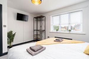 een slaapkamer met een bed met twee handdoeken erop bij Driveway Parking Garden Large House Good Location 