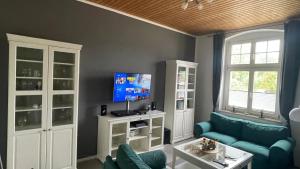 a living room with a blue couch and a tv at Alte Post - Erdgeschoß in Gützkow