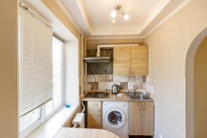 a small kitchen with a washing machine and a window at Kvartirkoff na Polku Azov 32b in Kyiv