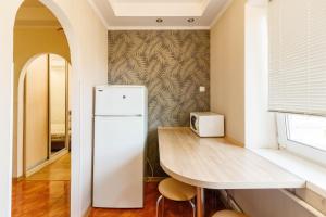 a kitchen with a table and a white refrigerator at Kvartirkoff na Polku Azov 32b in Kyiv