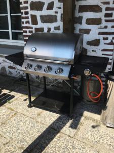 a grill sitting on a stand next to a building at Gasthof Feische in Hellefeld