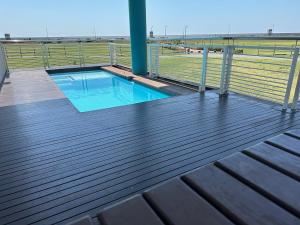 a wooden deck with a swimming pool on a baseball field at Point Beach #Accommodation - Durban Beach & Waterfront Canals EPIC VIEWS in Durban