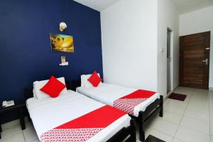 2 camas en una habitación con paredes azules y almohadas rojas en Oasis Ayurveda resort en Wadduwa