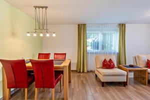 Un comedor con una mesa y sillas rojas. en Ferienwohnung Haus Irma, en Höchenschwand